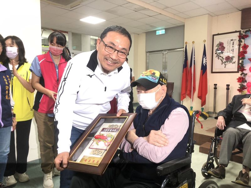 板橋榮家歡慶重陽 侯友宜百歲人瑞敬老金 12 《圖說》侯友宜市長致贈99歲新北敬老獎牌。〈板橋公所提供〉