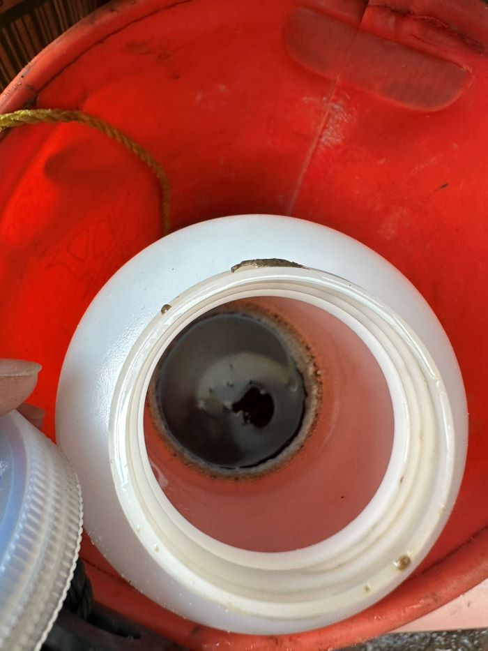 《圖說》稽查人員使用白色採樣瓶裝取污染油污。〈環保局提供〉