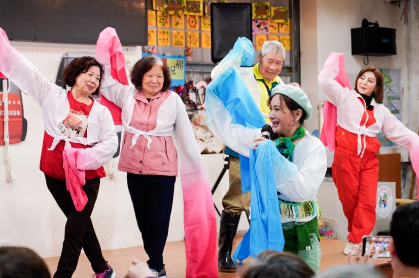 娛樂牡丹心據點長輩 〈台灣優質生命〉獻藝又送暖 8 《圖說》知名歌仔戲演員陳亞蘭教長輩舞動水袖,台上右1為王彩樺 右2為牡丹心社區協會理事長陳專森。〈社會局提供〉