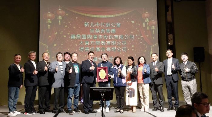 《圖說》地政局長汪禮國（中）和社會局副局長許秀能（中右1）代表侯友宜市長回贈感謝牌給不動產代銷經紀商業同業公會理事長陳春諒（中左1）。〈社會局提供〉