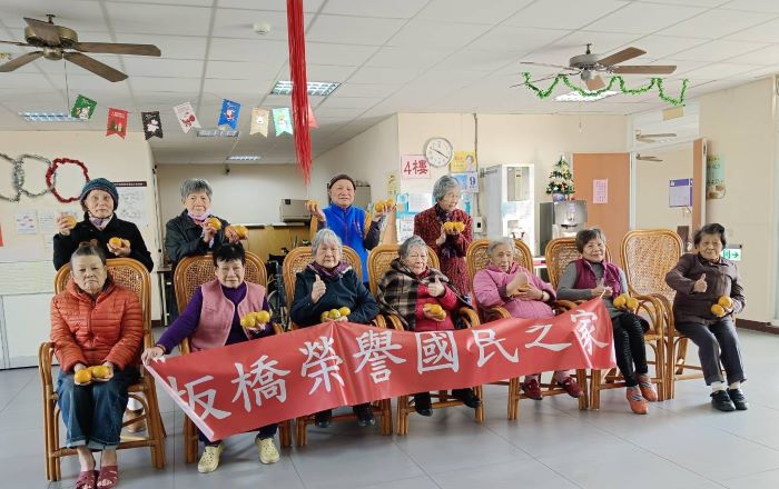 《圖說》板橋榮家長輩開心展示總統府致贈的「馬到成功、大吉大利」茂谷柑。〈板橋榮家提供〉