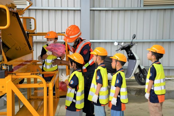 《圖說》小小清潔隊員將垃圾丟入垃圾車,體驗垃圾清運的過程。〈環保局提供〉