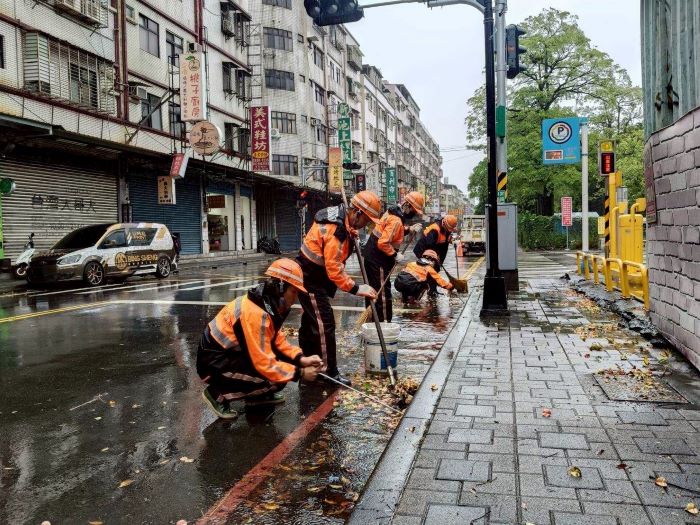 《圖說》清潔隊員於雨天執行路面清掃勤務。〈環保局提供〉