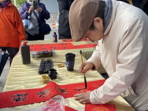 《圖說》2月7日來碧潭帶走客製春聯,用手寫的溫度,開啟馬到成功的一年。〈2025贈春聯資料照,觀旅局提供〉