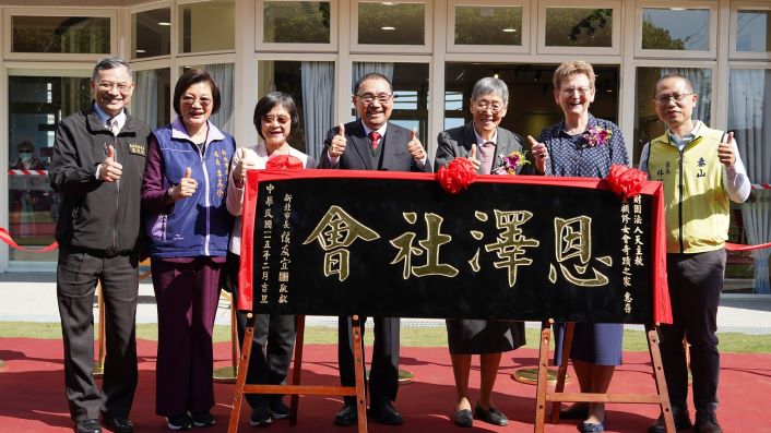 《圖說》新北市泰山奇蹟新家園日間照顧中心落成，侯友宜市長致贈「恩澤社會」匾額，左一民政局副局長莊茂坤、左二社會局長李美珍、左三衛生局長陳潤秋、右一泰山區長林俊宏。〈衛生局提供〉