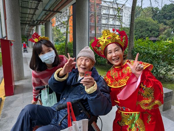 《圖說》陳桂美主任化身喜氣洋洋的財神爺,向長輩逐一致意拜年。〈板橋榮家提供〉