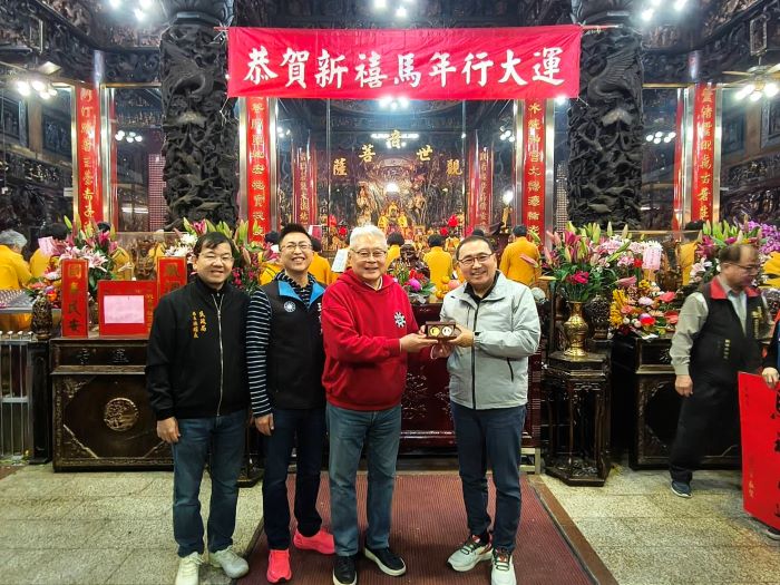 《圖說》市長侯友宜大年初二前往湧蓮寺參拜祈福，湧蓮寺主委回贈發財錢母。〈民政局提供〉