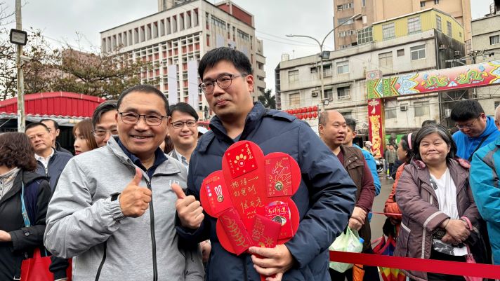 《圖說》在土城五穀先帝廟排在第一位的魏先生，連三年在五穀先帝廟及樹林濟安宮搶得頭香，非常有創意的將珍藏的各年福袋製作成手拿板，請侯友宜簽名紀念，表達對市政的支持。〈民政局提供〉