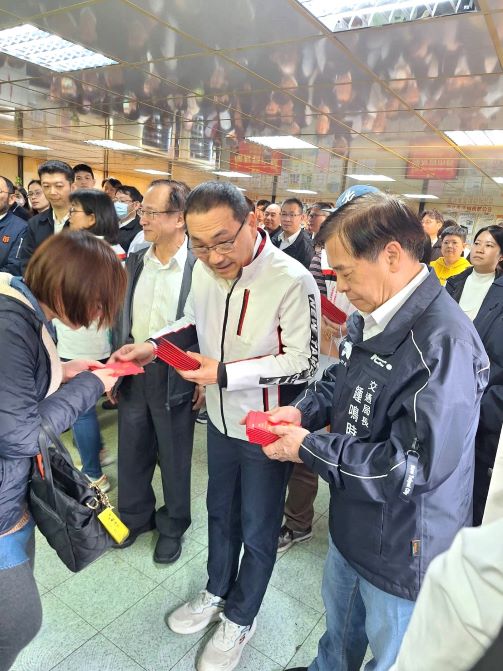 《圖說》侯友宜市長發放福袋給公車駕駛長，右一交通局長鍾鳴時。〈交通局提供〉