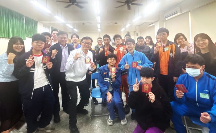 《圖說》教育局長張明文〈白夾克〉致贈小紅包為參與電動機車競賽的學生加油。〈教育局提供〉