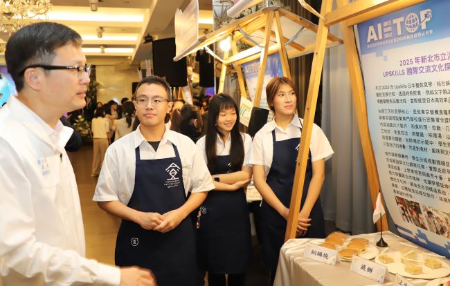 《圖說》教育局長張明文聆聽淡水工商日本餐飲職人養成之旅靜態展介紹。〈教育局提供〉