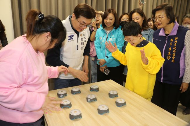 五股成州身障日照中心成立 新北第21家 7 《圖說》劉和然與學員在多感官影音互動設備中,搶按各色燈號。〈社會局提供〉