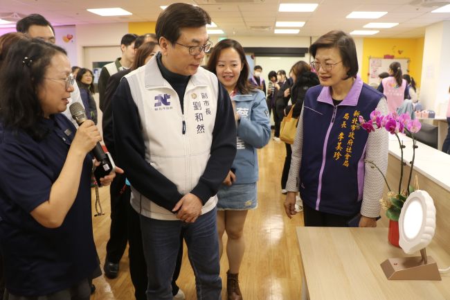 五股成州身障日照中心成立 新北第21家 8 《圖說》五股成州身障日照中心主任江明芬(左1)為劉和然介紹採用40赫茲(Hz)的貝殼燈,可穩定心智障礙者的情緒。〈社會局提供〉