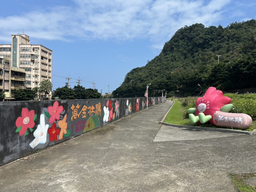 萬里瑪鋉運動公園，號召百人攜手彩繪70米長的「萬金杜鵑花牆」，打造永久社區地景，可至萬金杜鵑官網線上報名