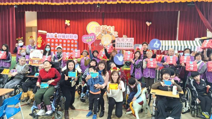 《圖說》八里愛心教養院舉辦「幸福加馬」抽福袋活動，愛心志工隊與院生們合影。〈社會局提供〉