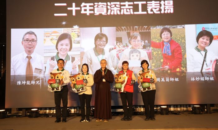 《圖說》靈鷲山法用法師贈送專屬的「五德公仔抱枕」給資深志工。(靈鷲山佛教教團提供)