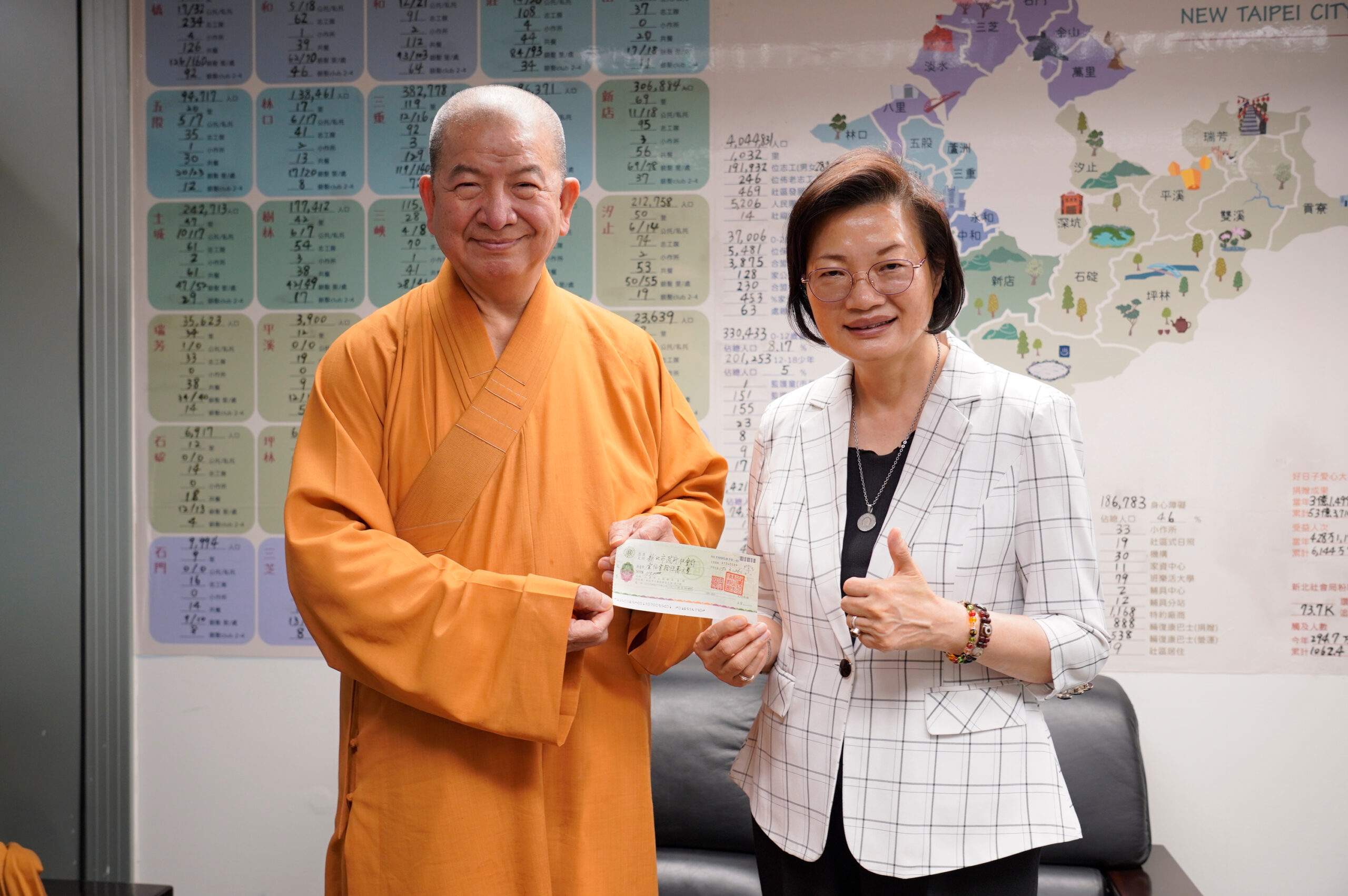 《圖說》新北市佛教會副理事長釋明光（左）代表捐贈善款，由社會局長李美珍代表受贈。〈社會局提供〉