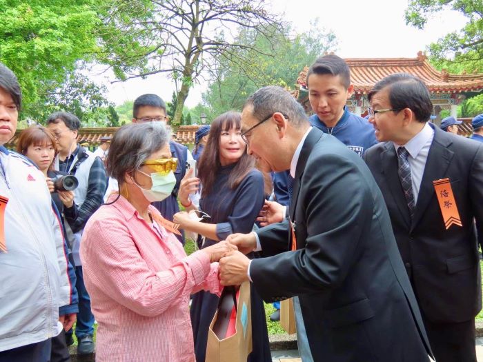 新北329舉行春祭大典 白玫瑰取代焚香致敬英靈 6 《圖說》市長侯友宜逐一與烈士家屬握手慰問,並致贈慰問品。〈民政局提供〉