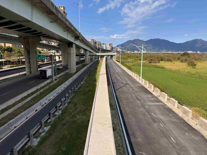 歷時三年告捷 新北二重疏洪道左岸加高完工 8 《圖說》疏左堤防緊鄰五股濕地,民眾可以透過越堤陸橋前往觀察生態。〈水利局提供〉