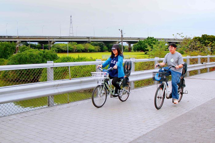 《圖說》兩人並肩騎行，展開悠閒的河濱單車之旅。〈高灘處提供〉