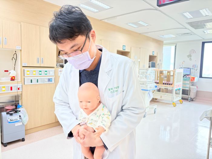 《圖說》邱俊哲醫師示範一歲以上幼童施行哈姆立克法，利用瞬間氣流將異物排出。〈土城醫院提供〉