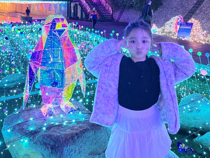 《圖說》光雕企鵝超吸睛,小女孩俏皮互動超療癒。〈水利局提供〉