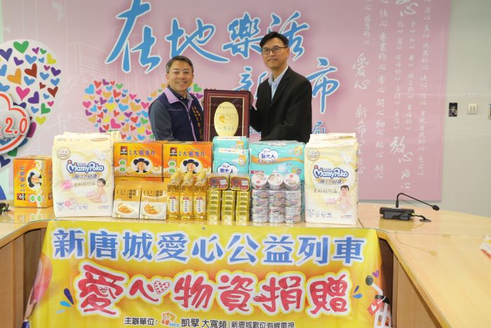 《圖說》社會局主任秘書黃逢明代表侯友宜市長回贈感謝牌給新唐城有線電視總經理廖咸隆。〈社會局提供〉