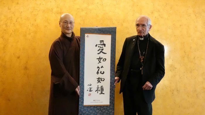 世界宗教博物館25周年 迎教廷代表展開跨信仰交流 6 《圖說》世界宗教博物館發展基金會執行長顯月法師(左)致贈創辦人心道法師所書的「愛如花如種」卷軸,給天主教義大利樞機主教托瑪士。〈宗博館提供〉