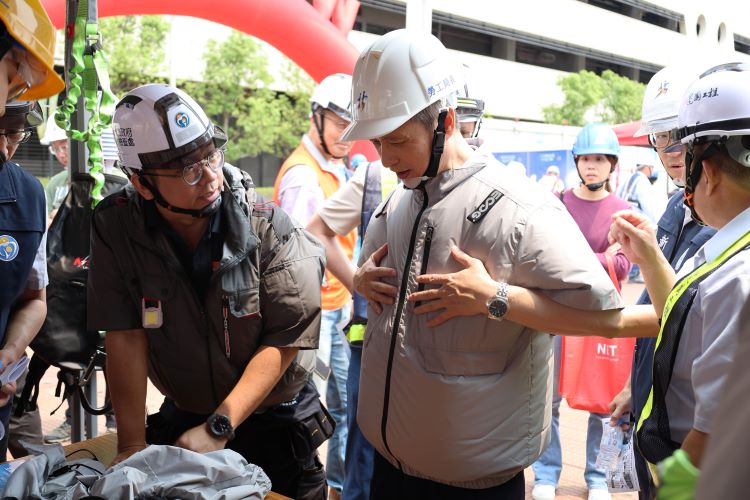 《圖說》勞工局長陳瑞嘉現場試穿風扇衣感受降溫效果。〈勞工局提供〉