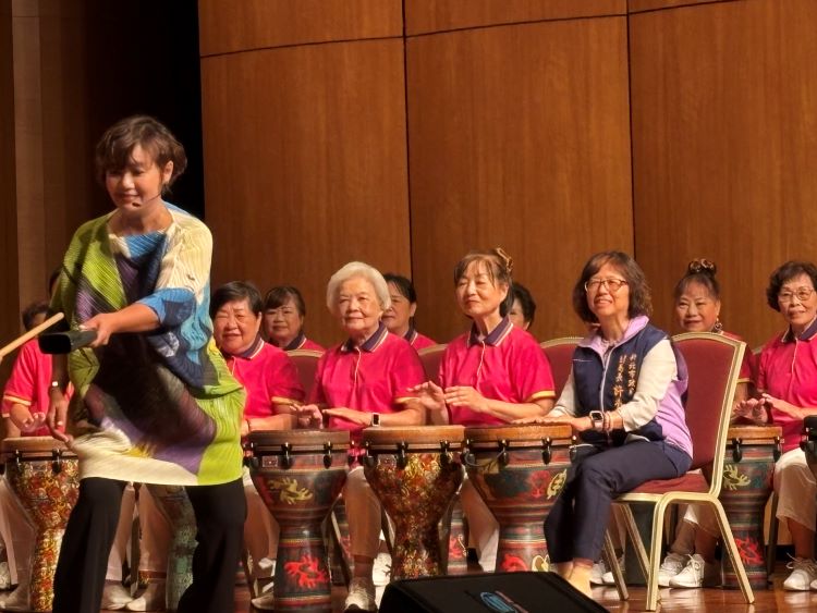 《圖說》新北蘆洲功學社銀髮俱樂部舉行週年成果展，社會局副局長許秀能〈前排右一〉與長者一同體驗打「墩鼓」。〈社會局提供〉