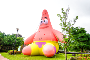 《圖說》新北市客家文化園區的「客家圓樓」變身為超吸睛的巨型「鳳梨屋」，還有超萌的海綿寶寶大氣偶坐鎮迎接，展現都會客家與國際 IP 跨界結合的創新趣味。〈客家局提供〉